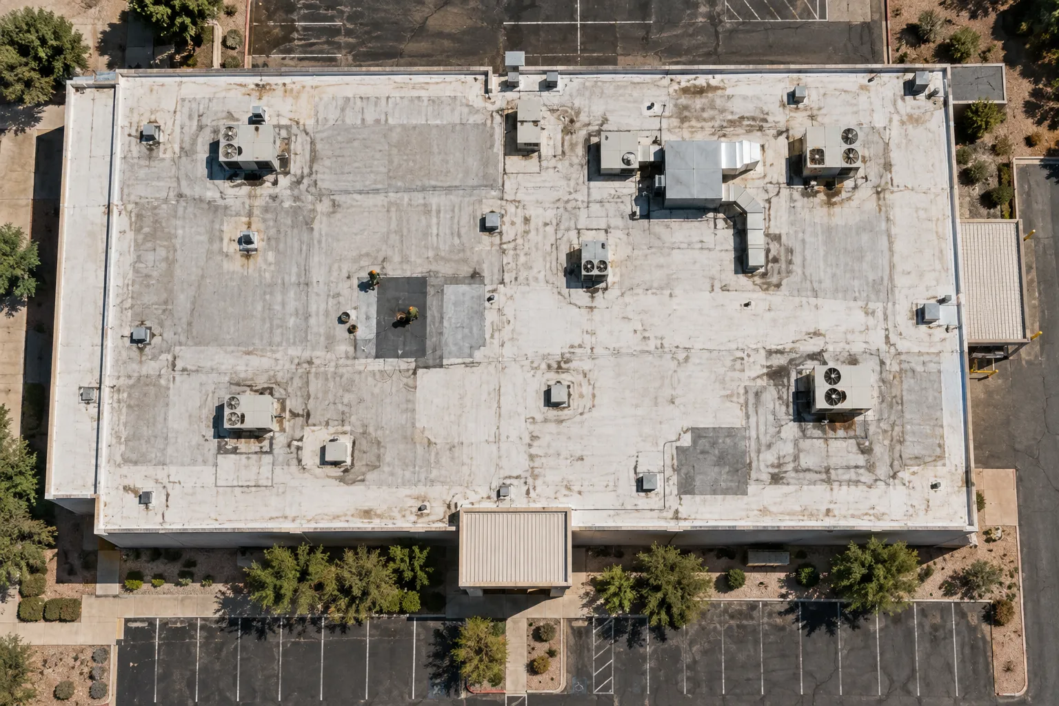 Overhead view of a patched flat commercial roof with rooftop units