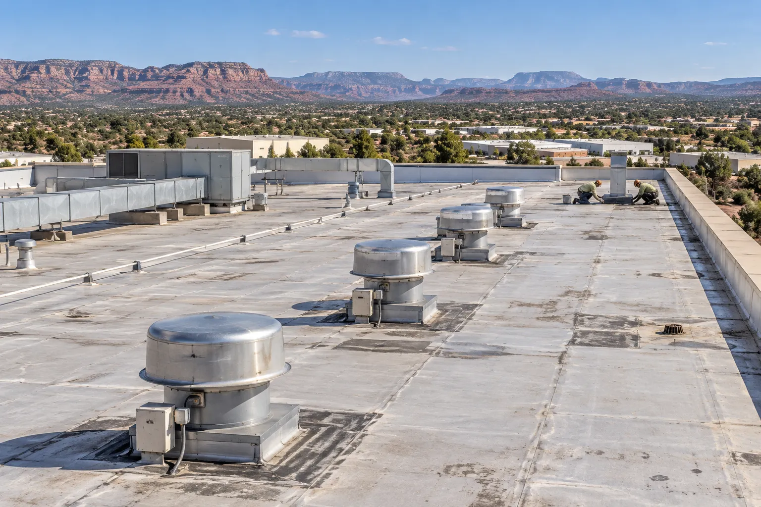 Industrial flat roof with rows of exhaust fans and ductwork