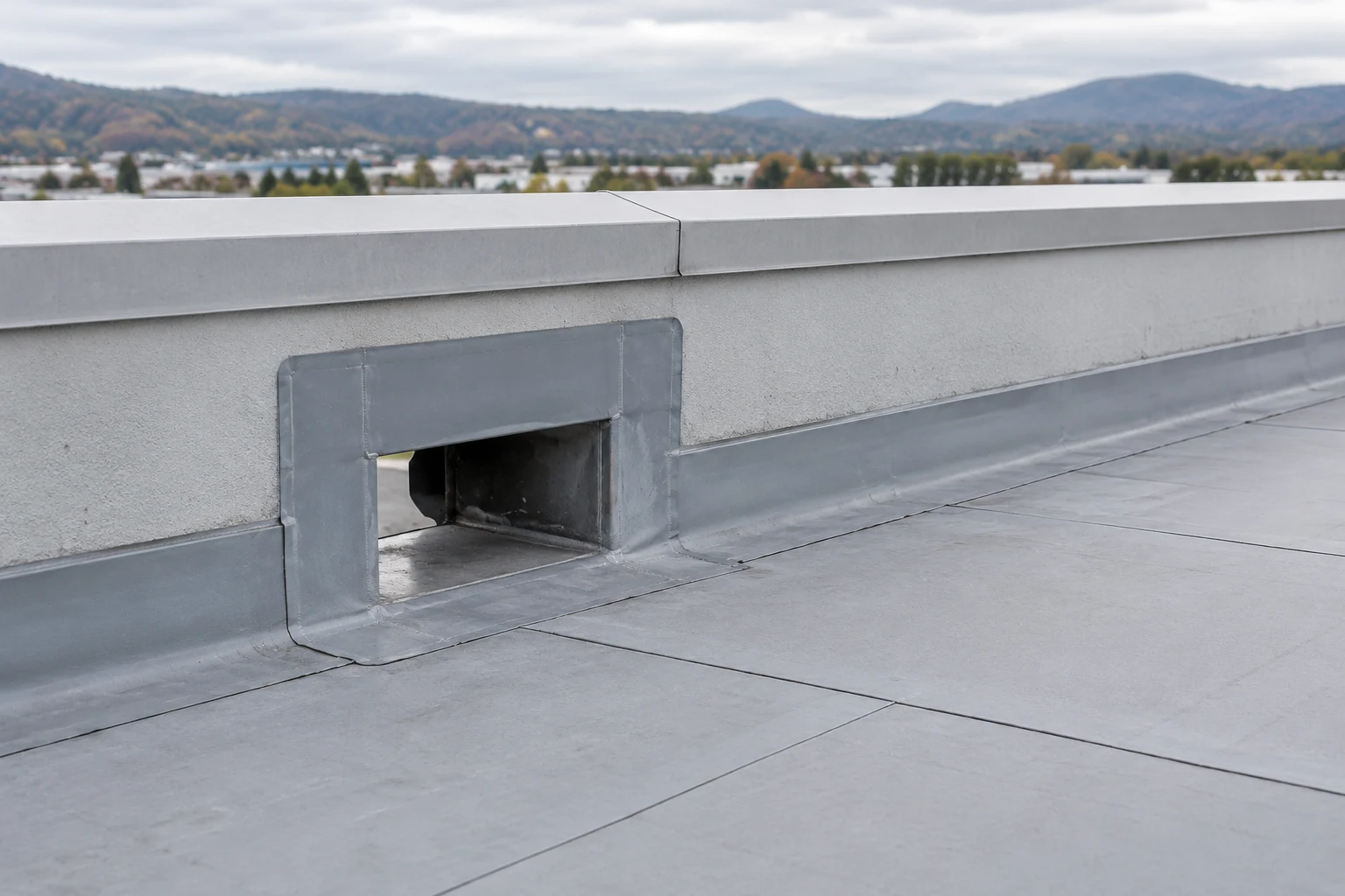 Drainage scupper at a commercial roof perimeter